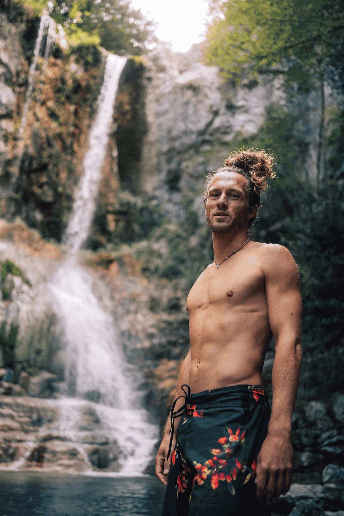 Man standing in front of a waterfall
